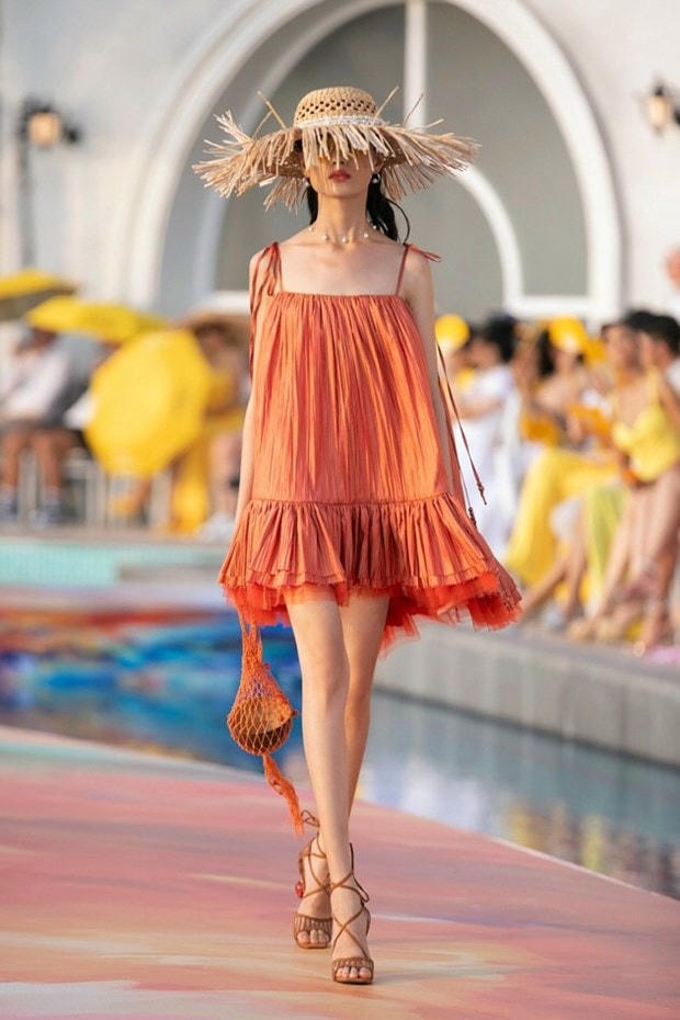 Thiết kế bay bổng và nữ tính của nhà thiết kế Lê Thanh Hòa được nhấn nhá bằng chiếc túi đan móc cùng màu váy.