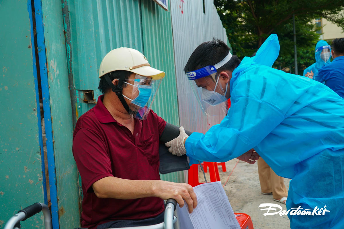 Trước khi tiêm, người dân phải khám sàng lọc trước.