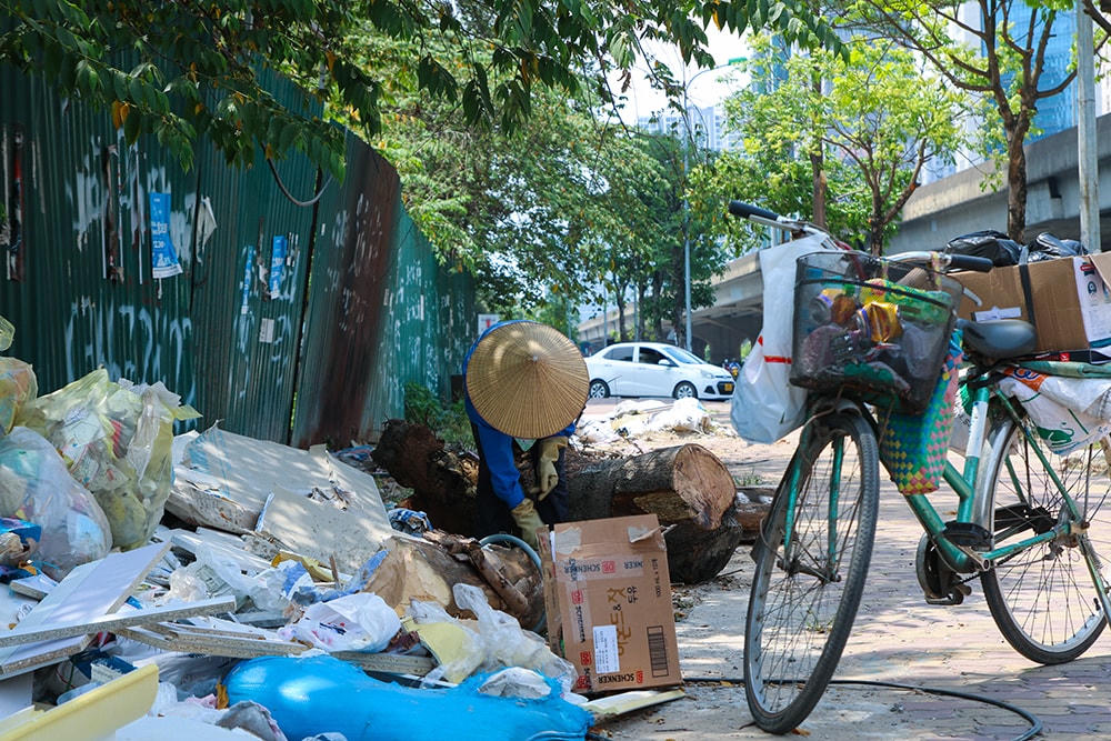 Người phụ nữ tranh thủ gom giấy loại bán phế liệu mưu sinh.