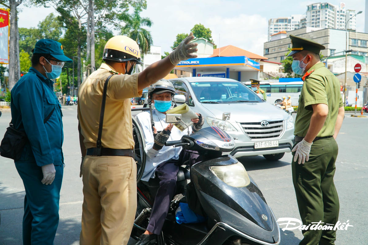 Một người dân đi sau khi trình đủ giấy tờ, được mời qua chốt.