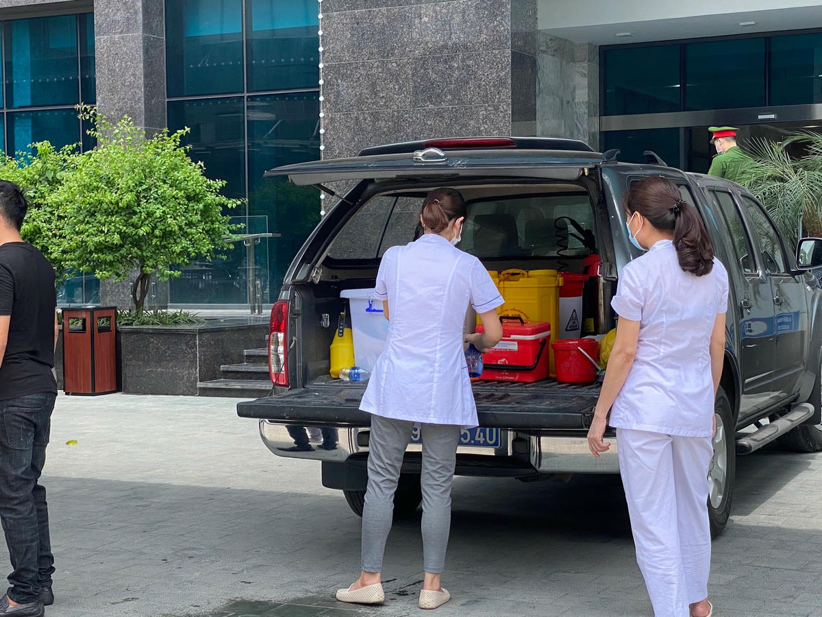 Lực lượng y tế tiến hành công tác phun khử khuẩn tại chung cư The Legacy. Ảnh: Lan Anh.