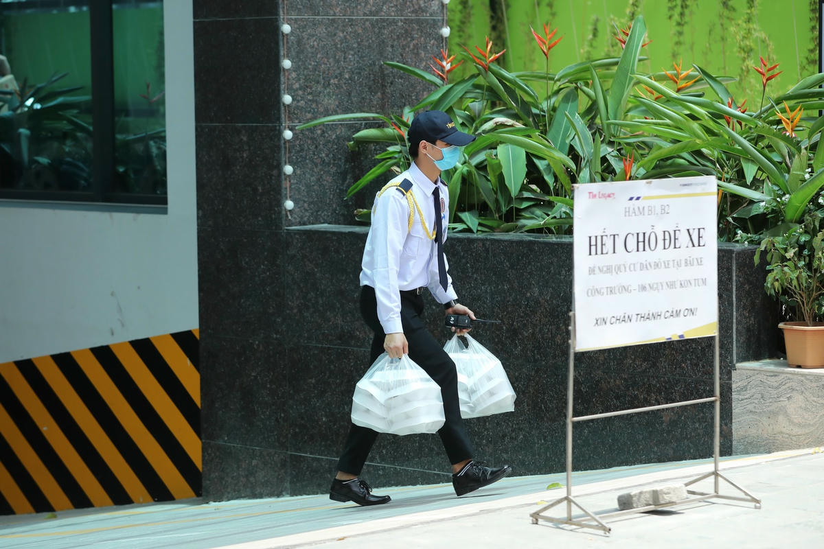 Bảo vệ chung cư The Legacy nhận hàng giúp người dân. Ảnh: Quang Vinh.