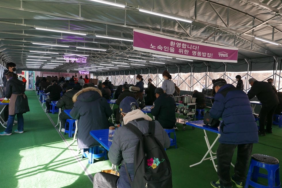 Mọi người được phục vụ bữa ăn miễn phí tại các bàn riêng trong bếp súp của Nhà thờ Myeongdong. Ảnh: Korea Times.