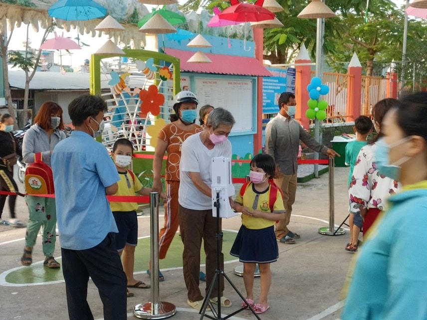 Học sinh được hướng dẫn khai báo y tế và rửa tay sát khuẩn trong ngày đầu tới trường (Ảnh: Đoàn Xá).