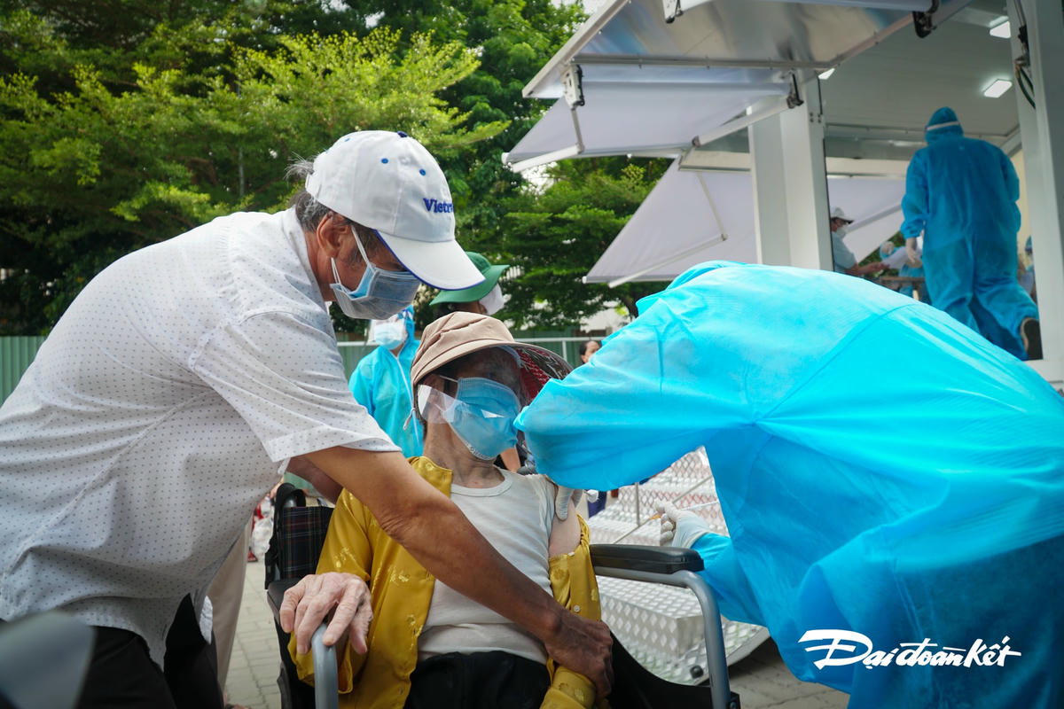 Do sức yếu, không đi lên cầu thang, tổ tiêm vaccine cũng đã bố trí 1 bàn tiêm khác cạnh xe nhằm mục đích tiêm vaccine.
