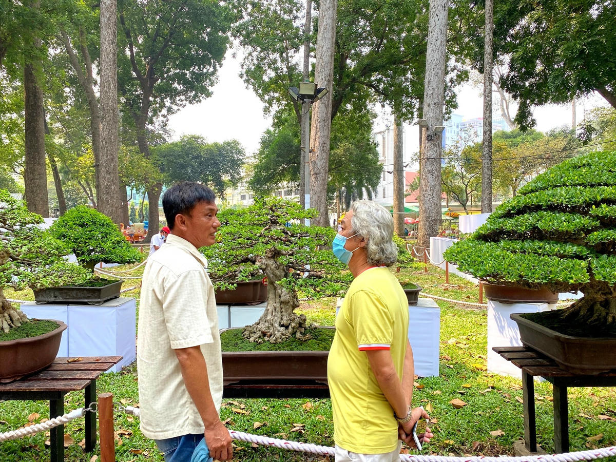 Nghệ nhân và du khách trao đổi kinh nghiệm chơi cây cảnh. Ảnh: Đại Việt.