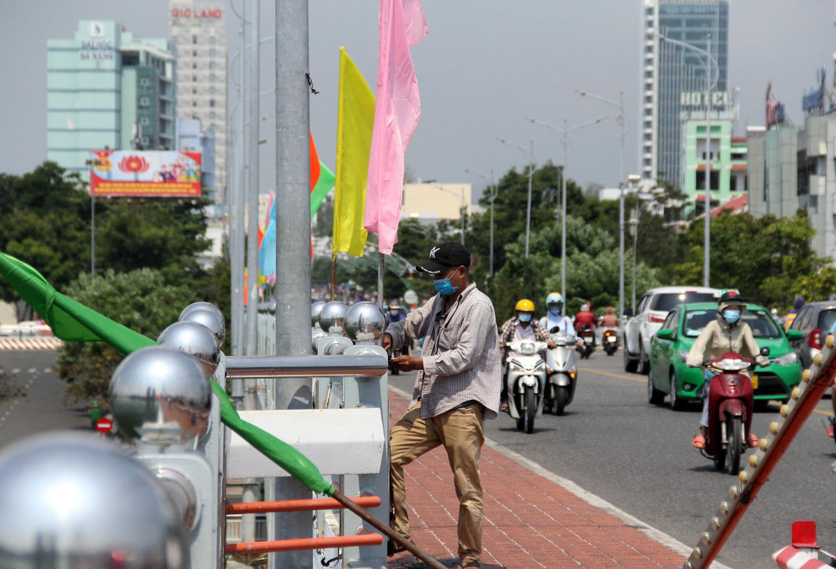 Các công nhân đang gấp rút hoàn thành việc treo cờ, băng rôn, pano… chào mừng lễ 30/4 - 1/5 trên các cây cầu và các tuyến phố.