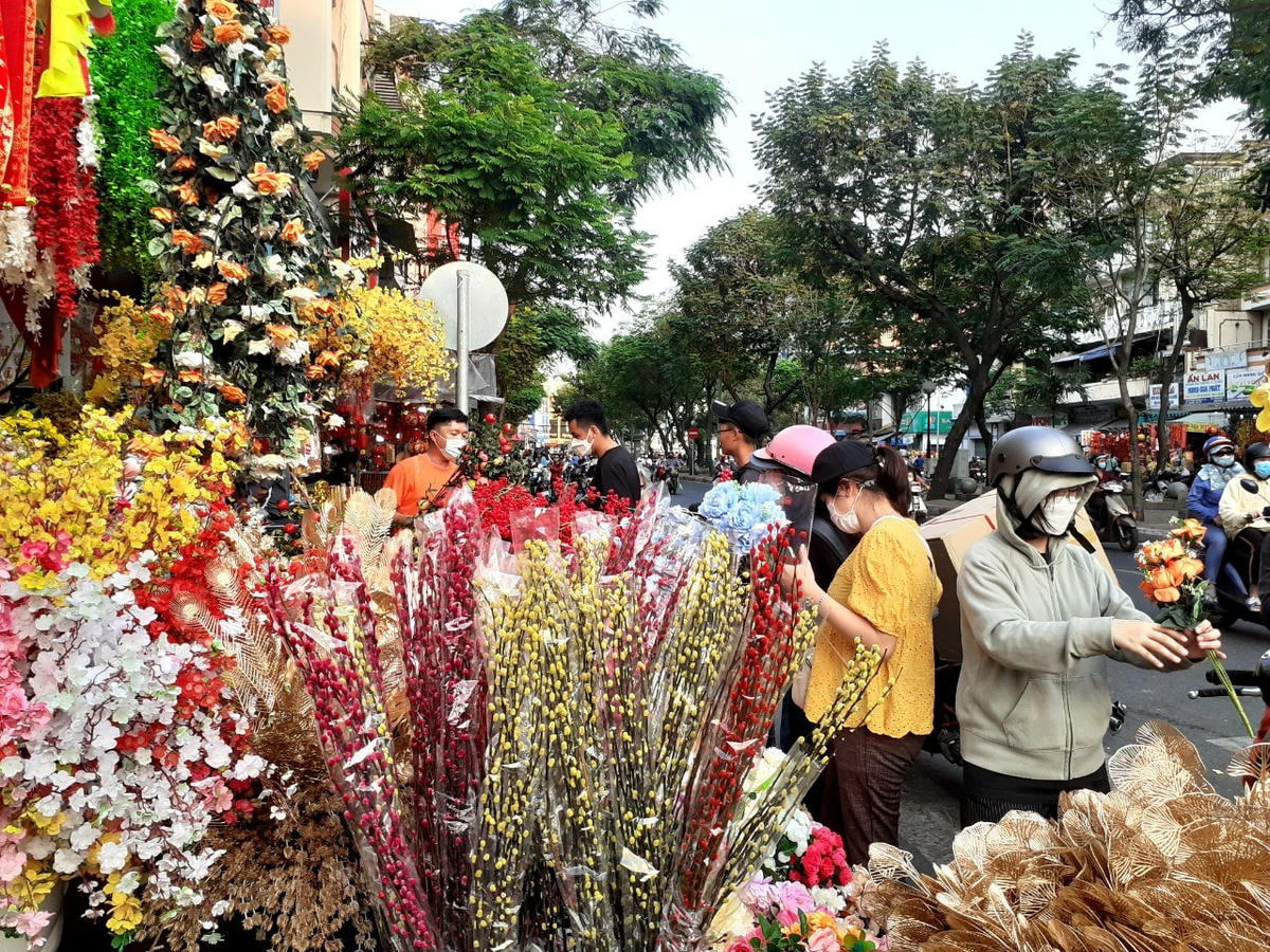 Nhiều người dân lựa chọn những cành hoa giả để chơi Tết.