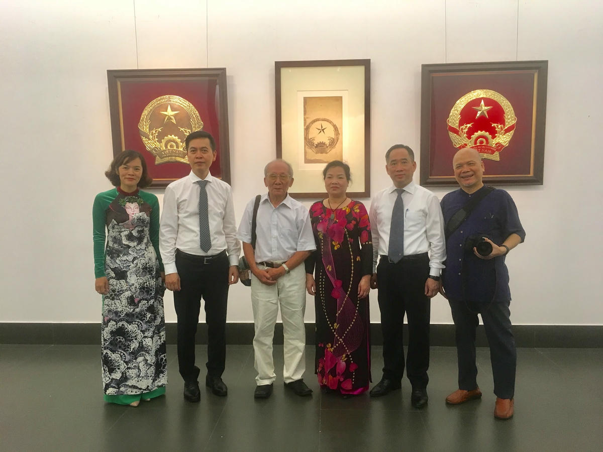 Đại diện BTC và gia đình, học trò họa sĩ Bùi Trang Chước chụp ảnh lưu niệm trước mẫu Quốc huy được chọn. 