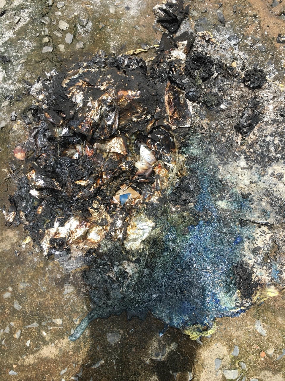 Một số vật tư y tế dùng để test Covid-19 chưa cháy hết bị người dân dùng nước dập lửa. Ảnh: CTV.