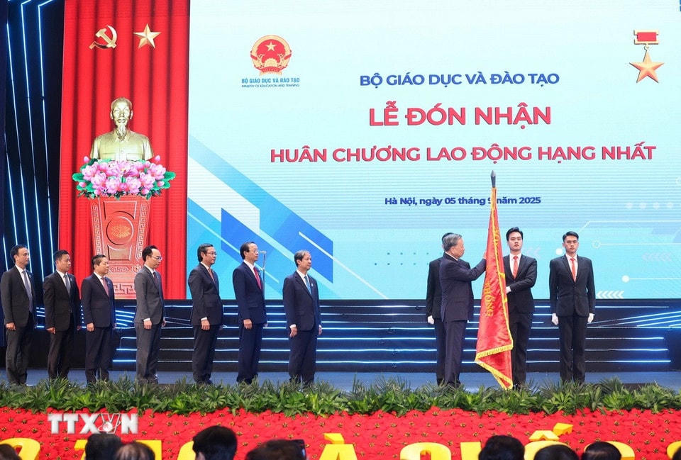 Tổng Bí thư Tô Lâm gắn Huân chương Lao động hạng Nhất lên lá cờ truyền thống của Bộ Giáo dục-Đào tạo. (Ảnh: Thống Nhất/TTXVN) ttxvn-0509-tong-bi-thu-nganh-giao-duc-11.jpg
