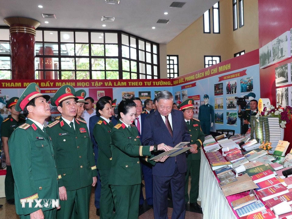 Tổng Bí thư Tô Lâm và các đại biểu tham quan Khu trưng bày ấn phẩm Quốc phòng. (Ảnh: Trọng Đức/TTXVN)