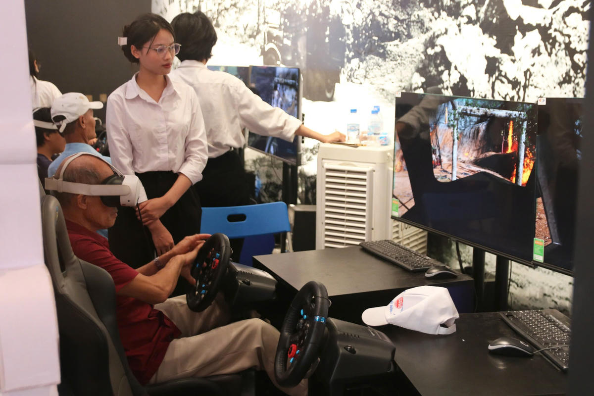 Du khách tham gia trải nghiệm phần mô phỏng lái xe không kính trên tuyến đường Trường Sơn huyền thoại. Ảnh: Tiến Đạt.