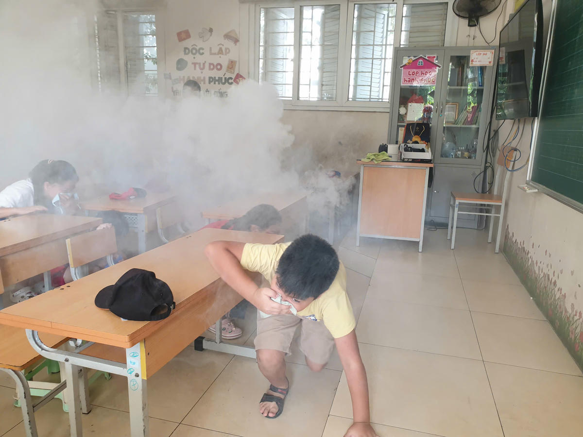 Hướng dẫn học sinh thoát khỏi đám cháy giả định tại buổi tuyên truyền.