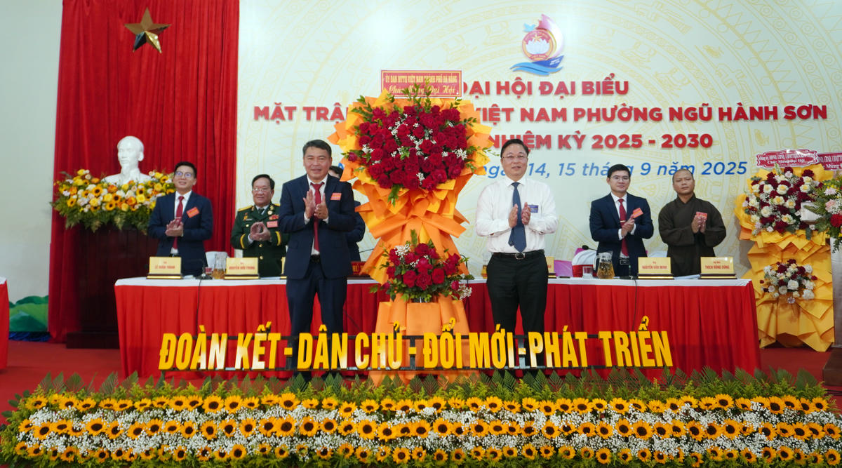 Ông Đặng Văn Kỳ, Chủ tịch Ủy ban Mặt trận Tổ quốc Việt Nam phường Ngũ Hành Sơn (bên trái) nhận lẵng hoa chúc mừng từ ông Lê Trí Thanh, Chủ tịch Ủy ban Mặt trận Tổ quốc Việt Nam TP Đà Nẵng. Ảnh: Như Ý.