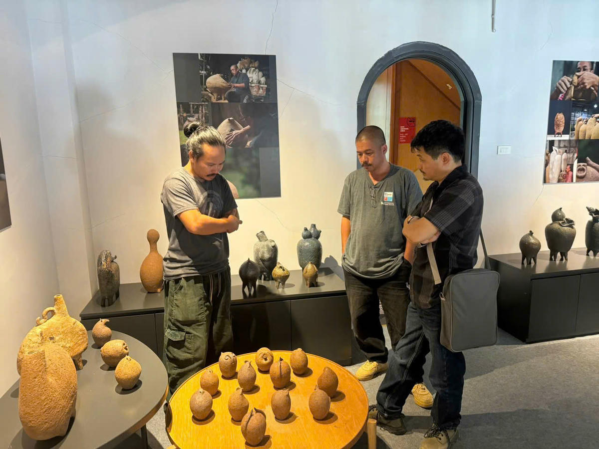 Nghệ sĩ Vũ Đức Hiếu cùng hai đồng nghiệp của anh bên các tác phẩm được trưng bày trong triển lãm "Nét Mường". Ảnh: HM