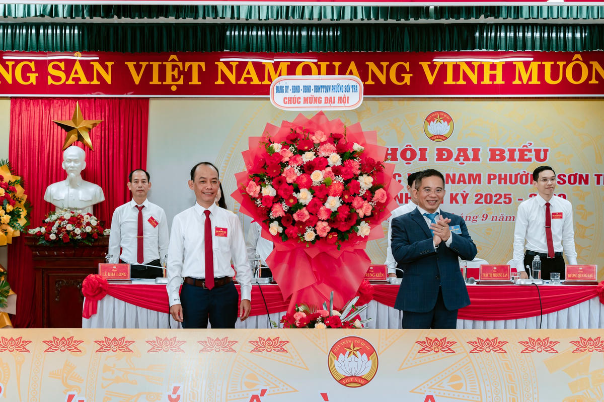 Ông Hoàng Sơn Trà (bên phải), Bí thư Đảng ủy phường Sơn Trà tặng hoa chúc mừng ông Lê Trung Kiên, Chủ tịch Ủy ban Mặt trận Tổ quốc phường Sơn Trà. Ảnh: Quang Học.
