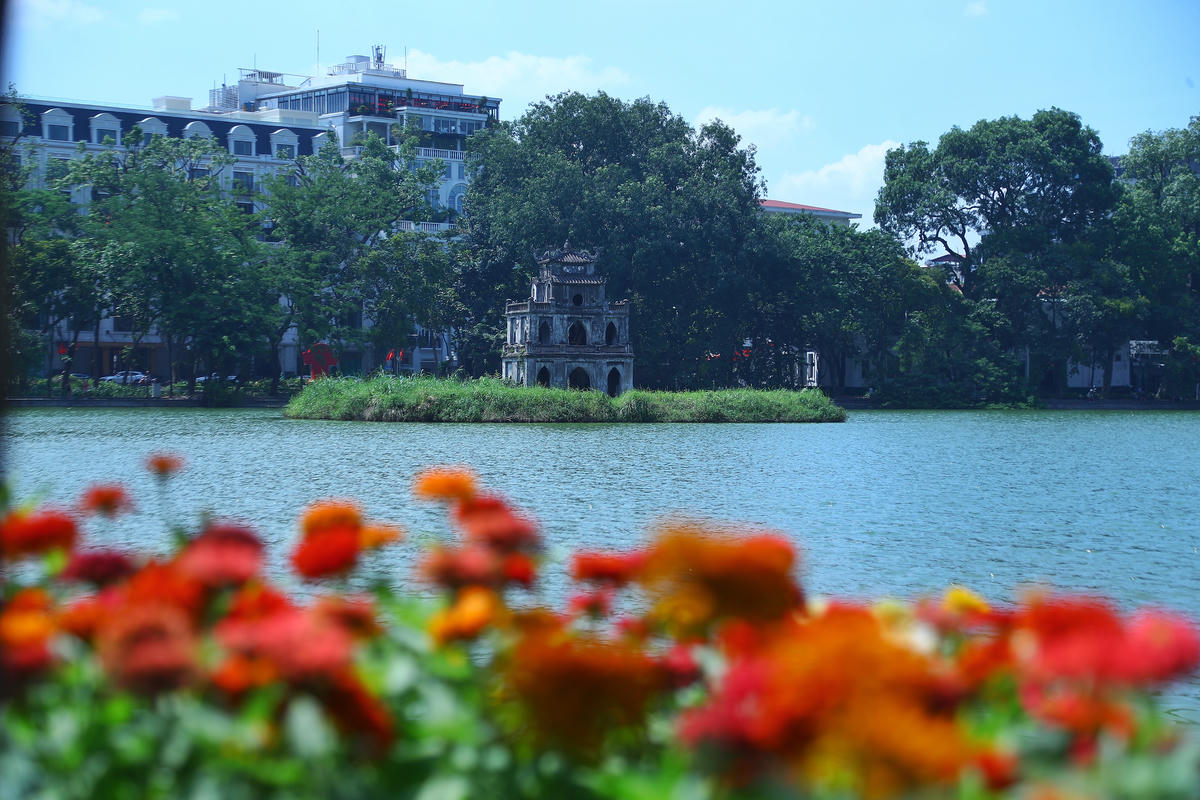 Tháp Rùa, nổi bật giữa không gian Hồ Hoàn Kiếm rực rỡ sắc hoa.
