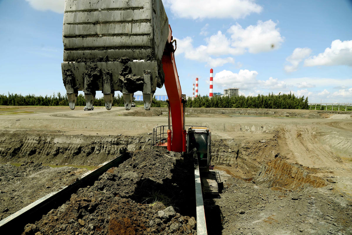 Tro xỉ ở bãi chứa được máy xúc đưa lên các xe ben vận chuyển về các nơi tiêu thụ. Ảnh: Trung Kiên.  