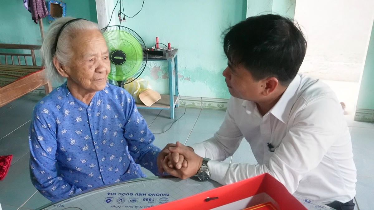 Bí thư Đảng ủy xã Hiệp Đức Lê Quang Quỳnh ân cần thăm hỏi Mẹ Việt Nam anh hùng Trần Thị Thái. Ảnh: CV.