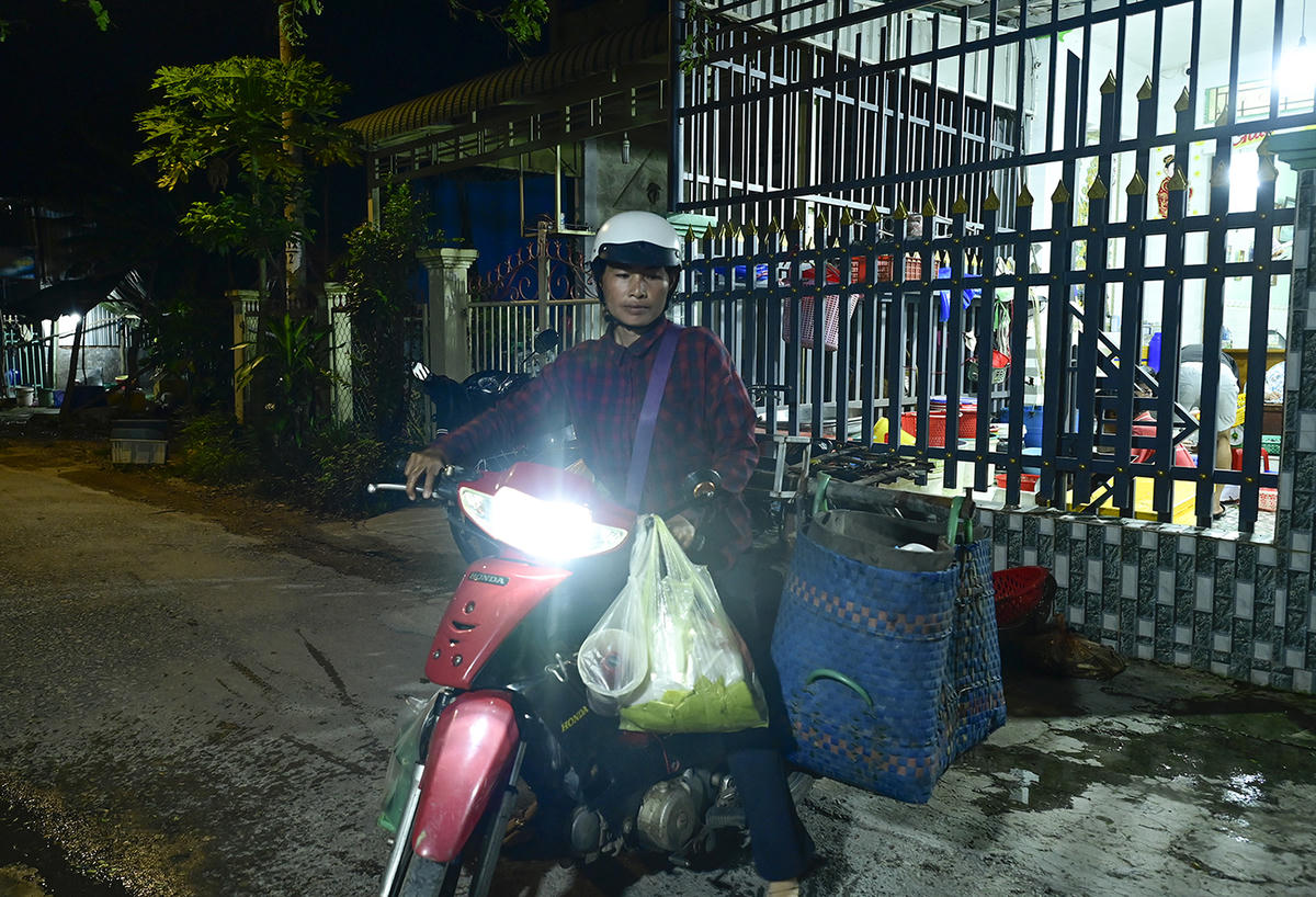 Chị Nguyễn Thị Đầy - tiểu thương đến “chợ ma” cá đồng cân cá đem ra chợ bán lại cho người dân. Ảnh Nguyễn Minh