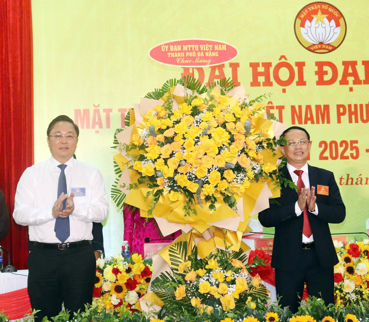 Ông Lê Trí Thanh (bên trái), Chủ tịch Ủy ban Mặt trận Tổ quốc Việt Nam TP Đà Nẵng tặng hoa chúc mừng ông Trần Trung Thanh, Chủ tịch Ủy ban Mặt trận Tổ quốc Việt Nam phường Cẩm Lệ. Ảnh: Nguyễn Tú.