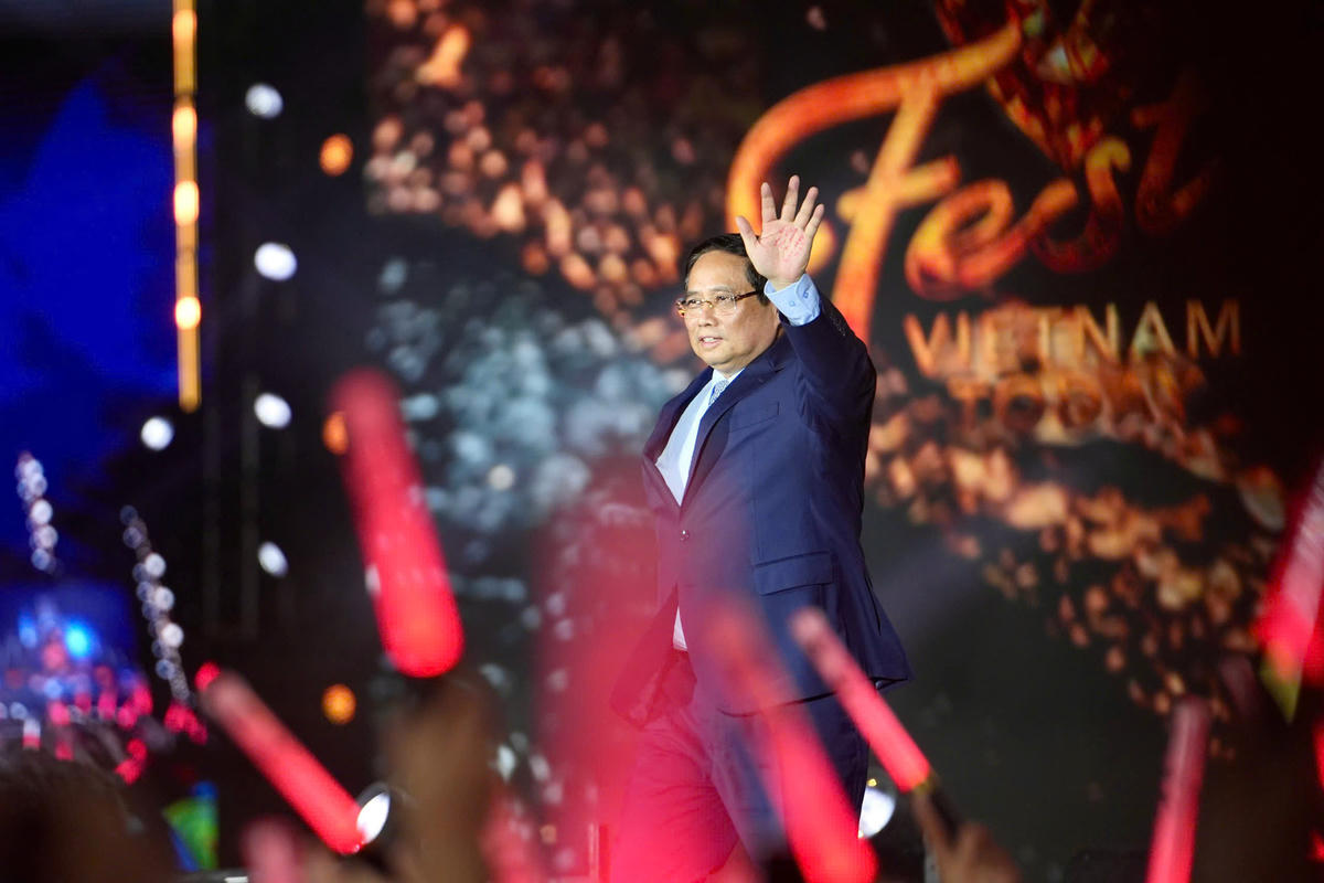 Thủ tướng Phạm Minh Chính vẫy chào đông đảo khán giả có mặt tại đại nhạc hội. Ảnh: VTV.