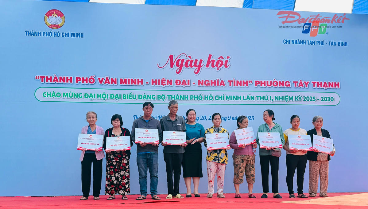 Trao thẻ bảo hiểm y tế cho các hộ gia đình có hoàn cảnh khó khăn. Ảnh: Văn Phong.