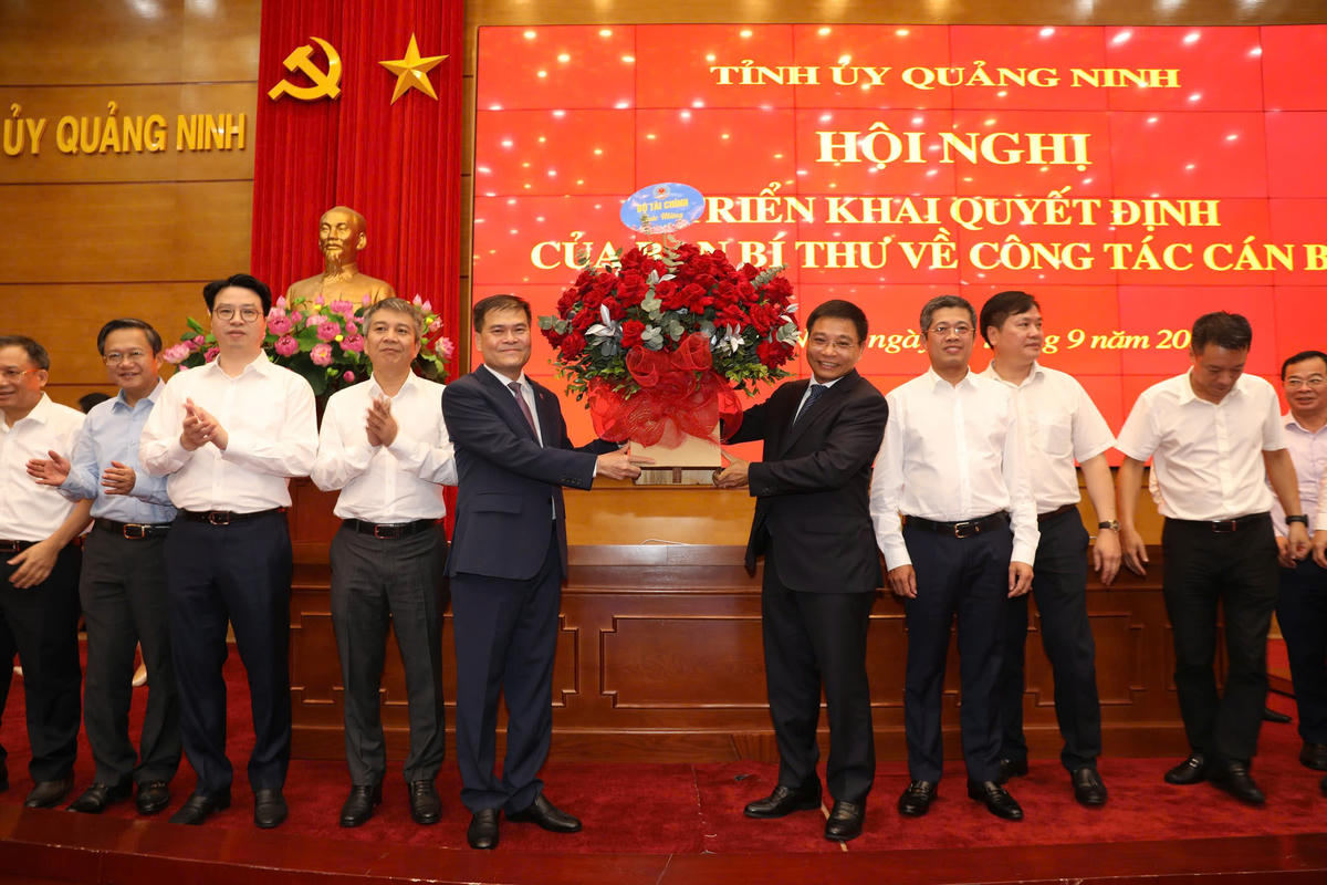 Bộ trưởng Bộ Tài chính Nguyễn Văn Thắng tặng hoa chúc mừng ông Bùi Văn Khắng, Phó Bí thư Tỉnh ủy Quảng Ninh. Ảnh: QMG