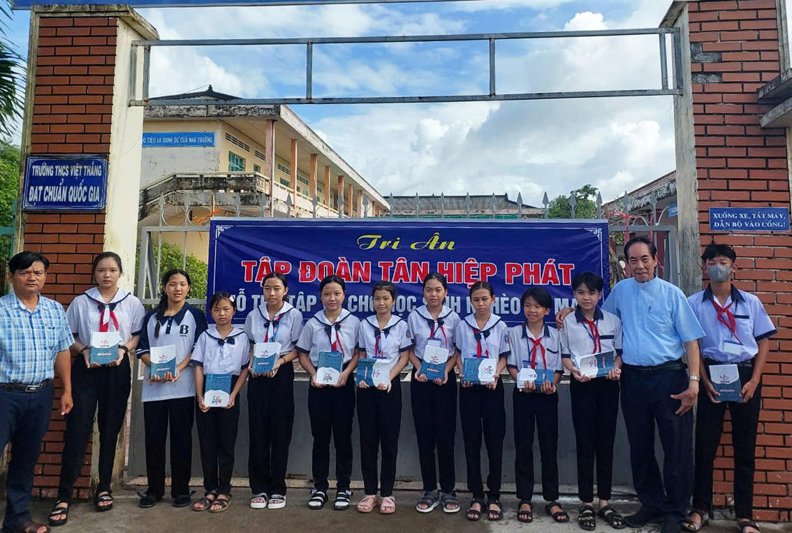 Linh mục Nguyễn Văn Vinh -
Chủ tịch Ủy ban Đoàn kết Công giáo tỉnh Cà Mau (thứ 2 từ phải sang)
trao sách vở cho các em học sinh.