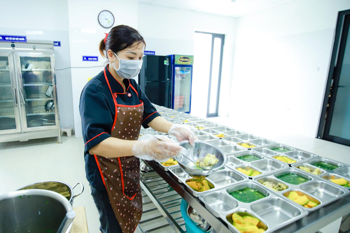    Chuẩn bị bữa ăn bán trú cho các em học sinh tại một trường học ở Hà nội. Ảnh: Quang Vinh   