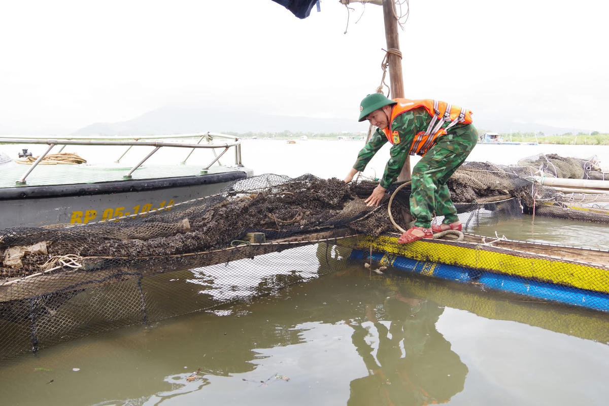 Bộ đội giúp ngư dân phường Hải Bình chằng chống các lồng nuôi thủy sản sáng 27/9. Ảnh: Lính xứ Thanh