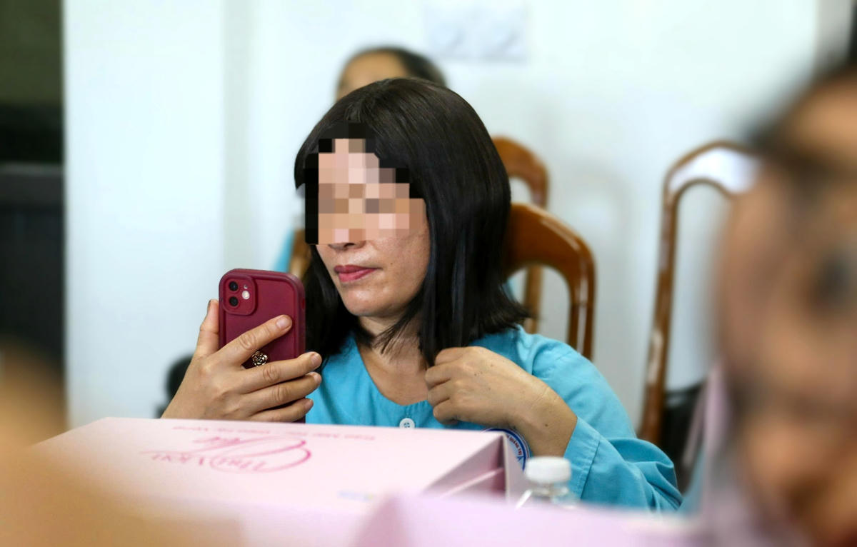 Bà N.
đưa điện thoại lên soi, ngắm nghía bản thân với bộ tóc mới được trao tặng. Ảnh:
Đỗ Văn.