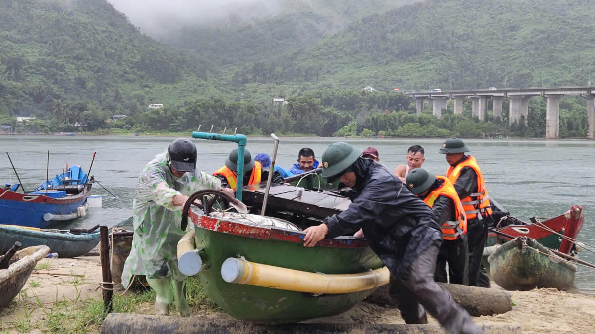 Lực lượng chức năng cùng người dân đưa tàu thuyền vào nơi tránh trú an toàn. Ảnh: D.M.