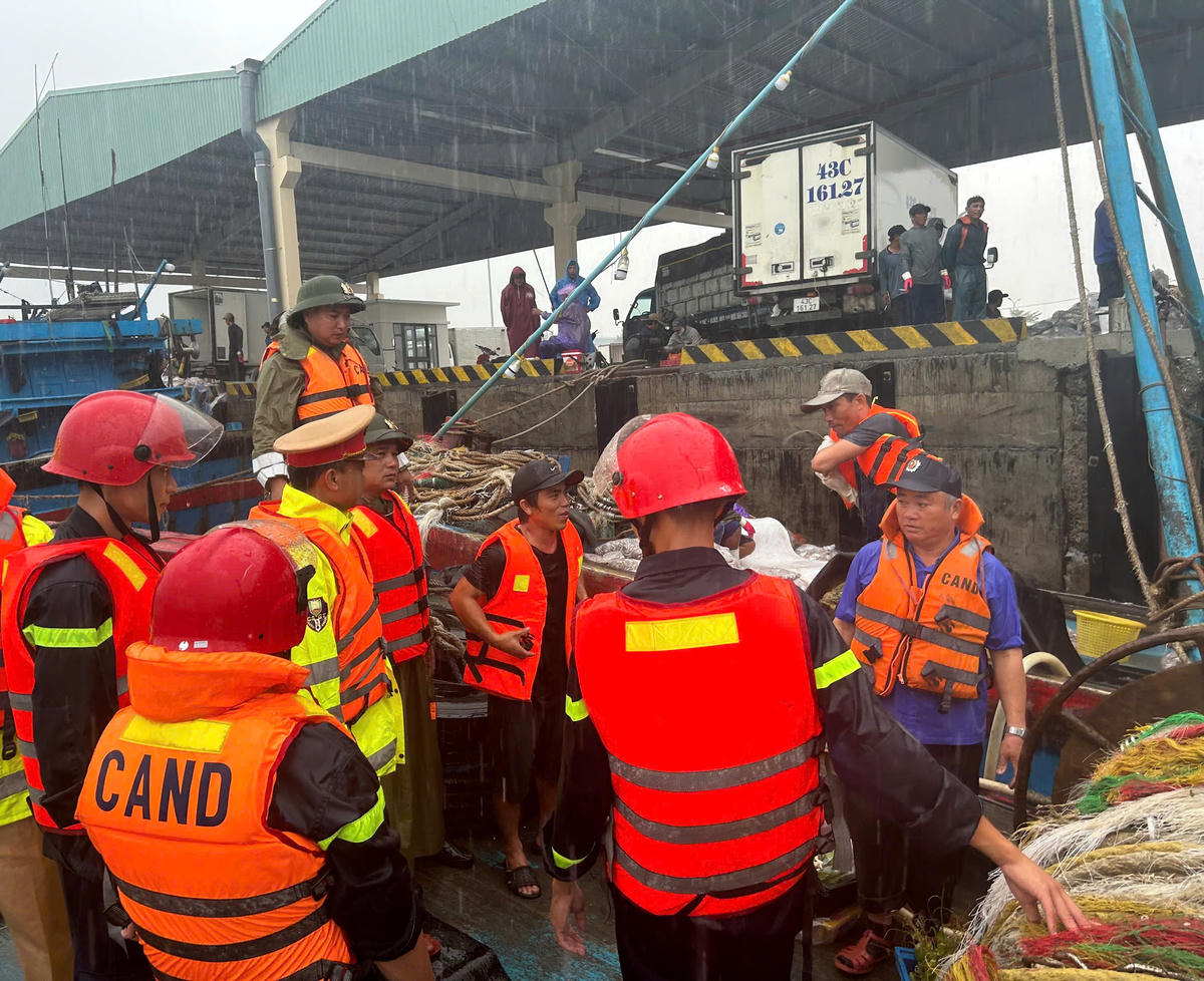 Công an thành phố hướng dẫn sắp xếp tàu thuyền tại ảng cá Thọ Quang. Ảnh: Nguyễn Tú.