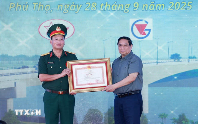 Thủ tướng Phạm Minh Chính tặng bằng khen cho đồng chí Nguyễn Tuấn Anh, Phó Tư lệnh Binh đoàn 12, Bộ Quốc phòng có thành tích xuất sắc trong tổ chức thi công dự án cầu Phong Châu mới. (Ảnh: Dương Giang/TTXVN).