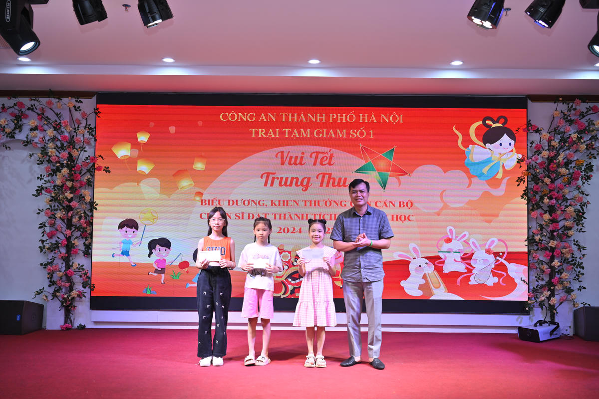 Đại tá Lê Mạnh Thanh Việt, Bí thư Đảng uỷ, Giám thị Trại tạm giam số 1 (Công an TP Hà Nội) tặng cho con cán bộ chiến sĩ đạt thành tích cao trong học tập năm học 2024-2025. Ảnh: Quang Lộc.