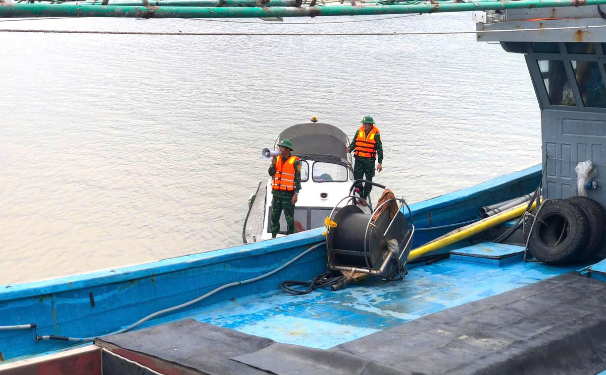 Bộ đội biên phòng Nghệ An dùng loa kêu gọi các tàu thuyền vào nơi tránh trú an toàn, trước diễn biến phức tạp của cơn bão số 10. Ảnh: ĐB