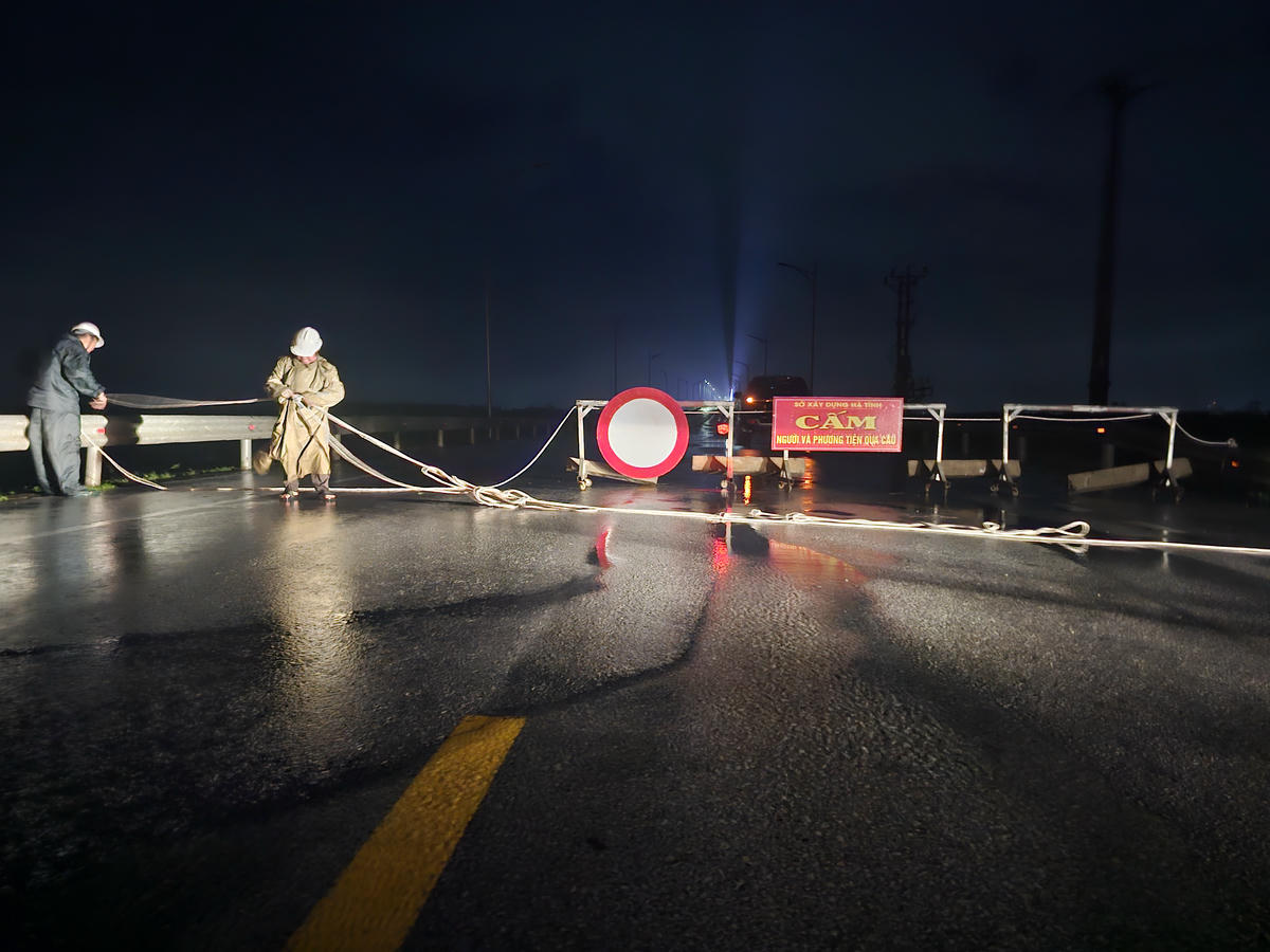 Cán bộ Ban quản lý cầu Cửa Hội lập rào chắn, cấm người và phương tiện lưu thông qua cầu trước giờ bão số 10 đổ bộ. Ảnh: Quốc Thanh