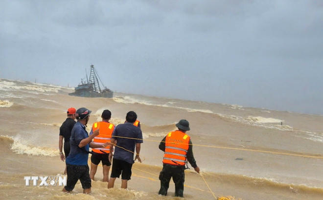 Cán bộ, chiến sỹ và nhân dân khẩn trương, tích cực cứu nạn hai tàu cá gặp nạn trên đường vào tránh trú bão số 10. (Ảnh: TTXVN phát).