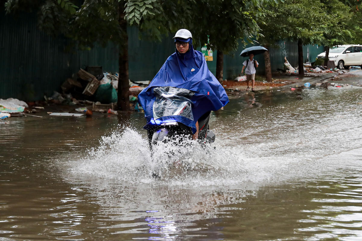 Nước ngập khiến người dân tham gia giao thông gặp khó khăn.