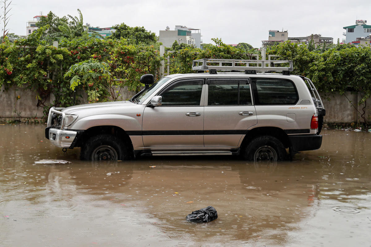 Nước ngập nửa bánh xe ô tô gầm cao.