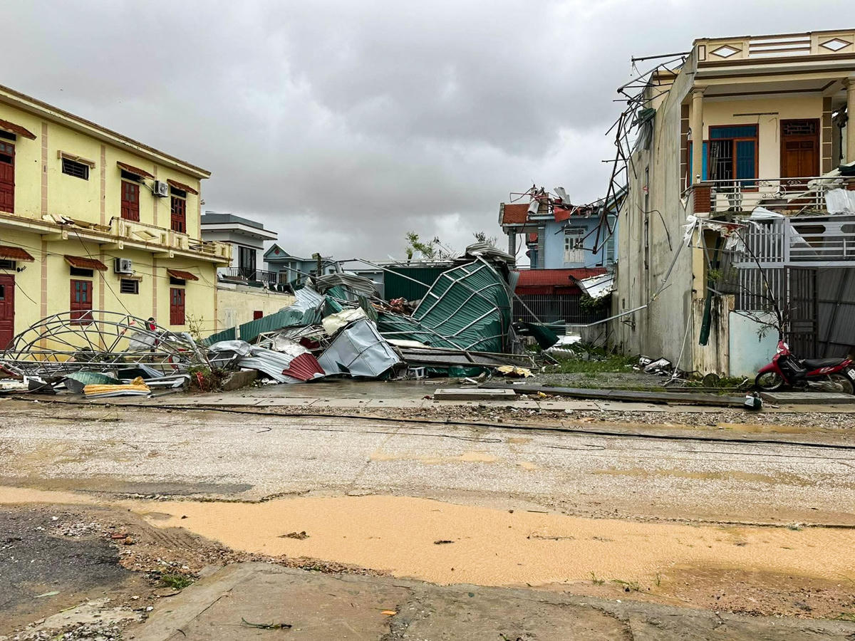 Mái tôn, biển hiệu khu dân đổ sập, rơi xuống đất ở xã Hoằng Giang. Ảnh: Khánh Trình.