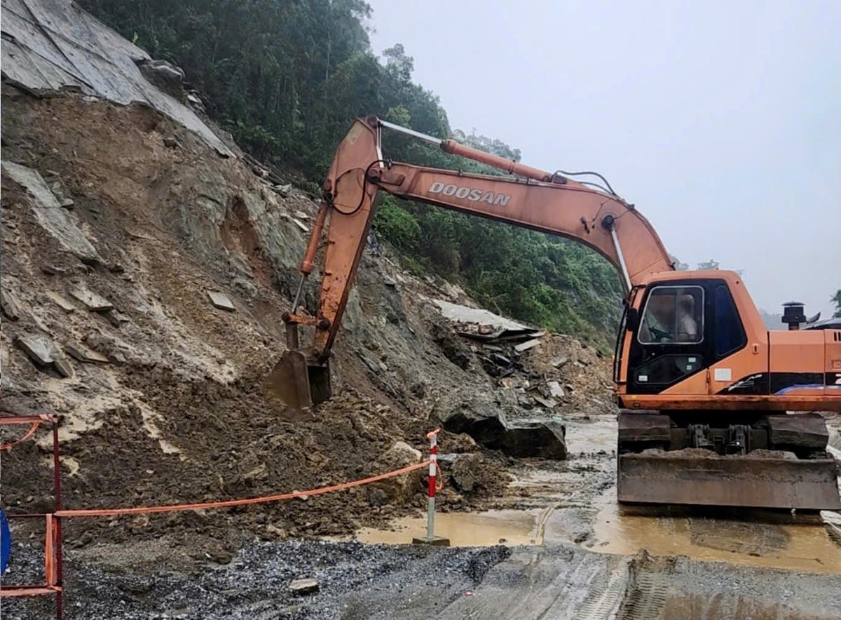 Tuyến quốc lộ 14E đoạn đi qua đồi núi đã phải có người hướng dẫn giao thông, lập biển báo. Ảnh: CV.