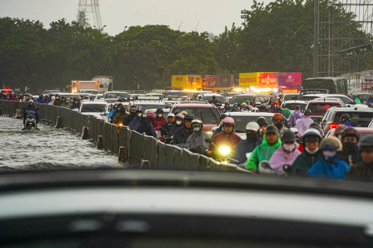 Mặt nước trắng xóa, người dân phải đi ra giữa đường để đảm bảo an toàn. 