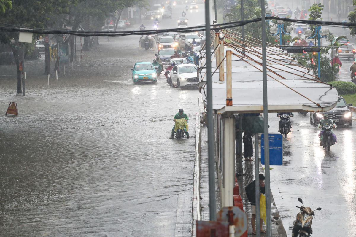 Nhiều người dân di chuyển qua các vũng sâu khiến xe bị chết máy.