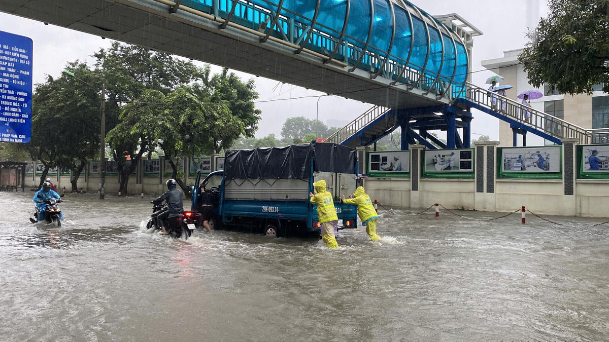 Tại đường Phùng Hưng (phường Hà Đông) các công nhân hỗ trợ tài xế xe tải di chuyển qua khu vực ngập do xe chết máy.