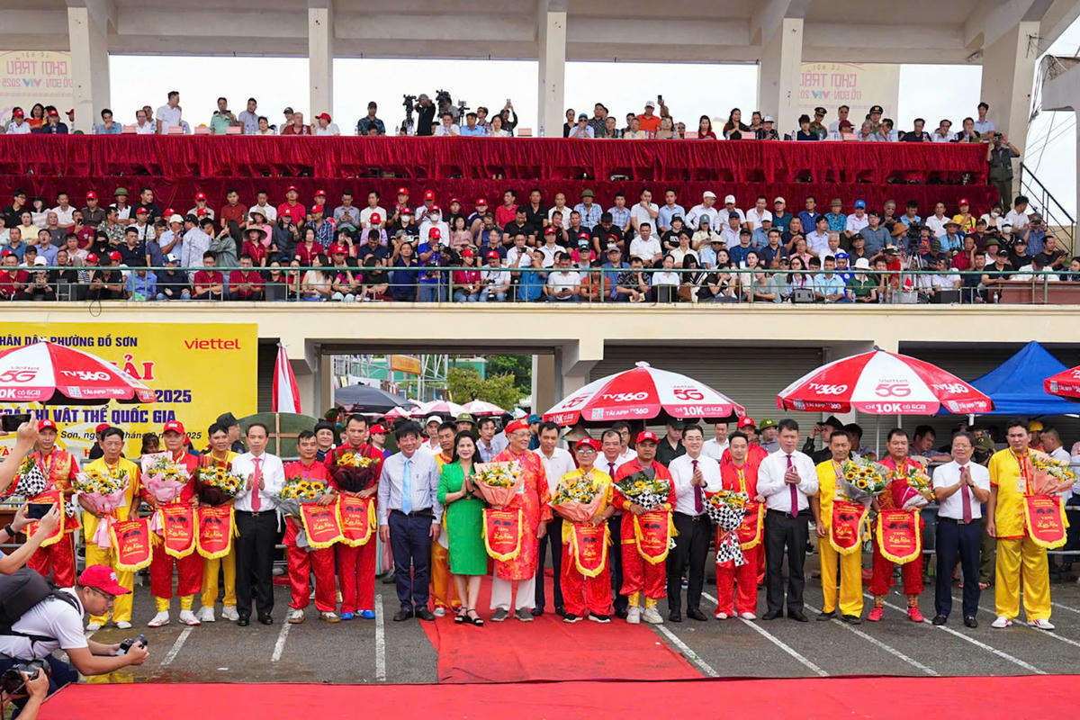 Lãnh đạo TP Hải Phòng tặng hoa và cờ lưu niệm cho các chủ trâu tham dự lễ hội. Ảnh: PT.