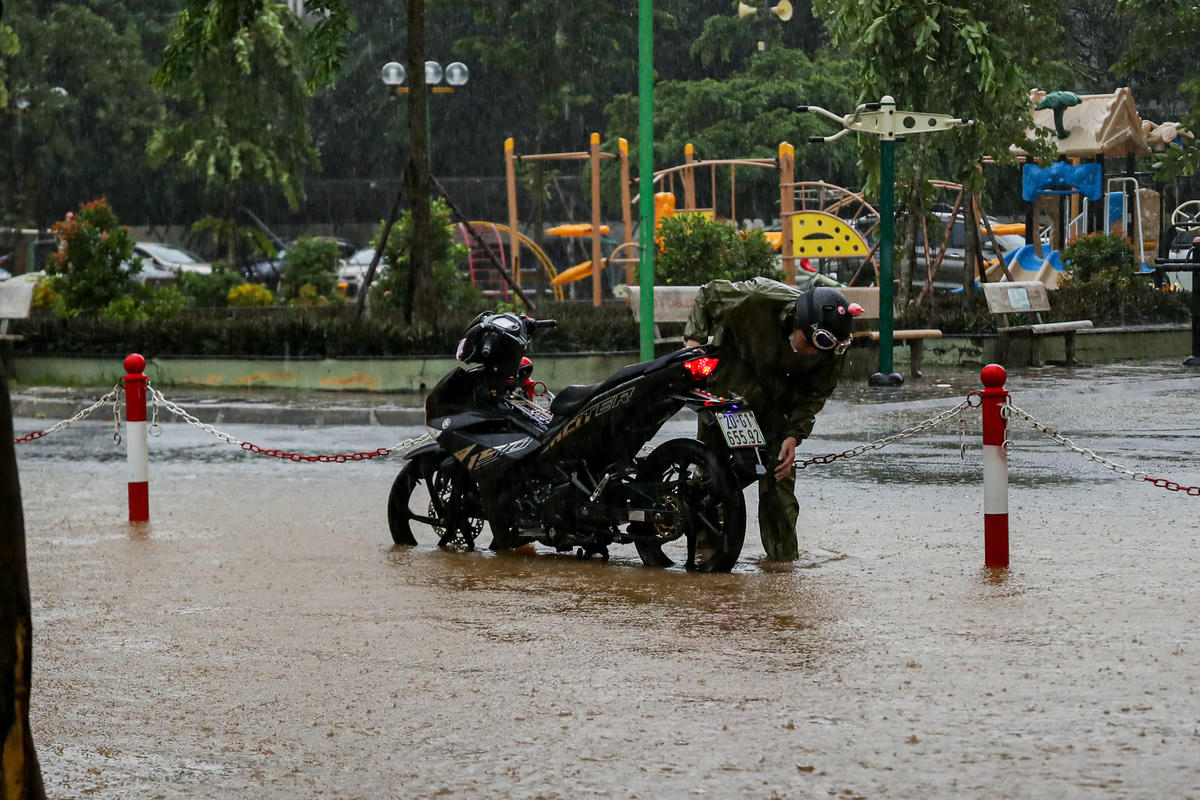 Xe bị chết máy, người dân phải dừng lại kiểm tra sau khi đi qua đoạn ngập úng.