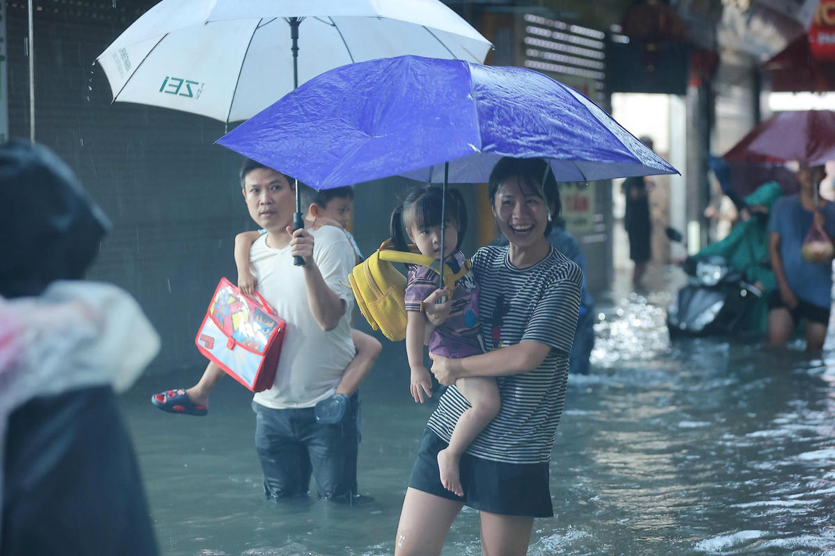 Theo ghi nhận của PV Báo Đại đoàn kết, khoảng 18h ngày 30/9, do mưa kéo dài, các tuyến đường xảy ra ngập úng, nhiều phụ huynh phải cõng con trở về nhà.